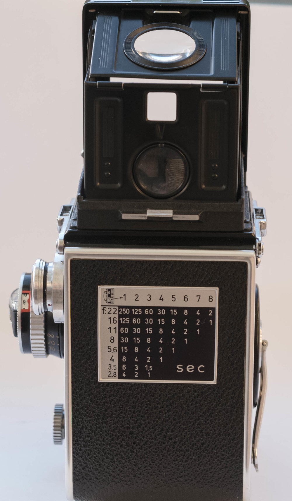 By pushing through the top of the lid of the camera when it is the raised position, you can get a see-through ‘look ahead’ sports type finder, but you would need to have done some focusing in advance or rely on depth of field. You could also use the magnifier window below for focus but in this position that window shows the image upside down.